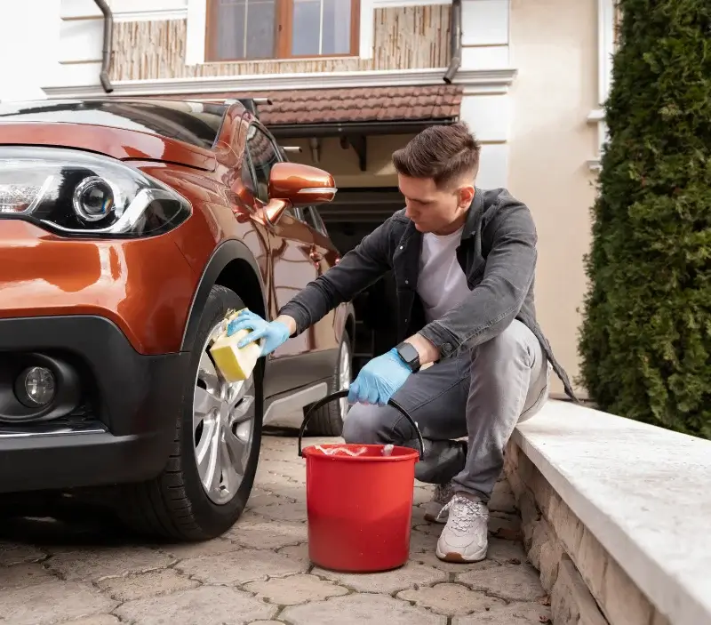 Lavage auto à domicile Bairon et ses environs : professionnel intervenant sur un véhicule